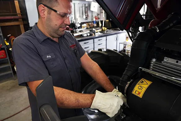 Lake Henry Implements service technician working on ag equipment in house.
