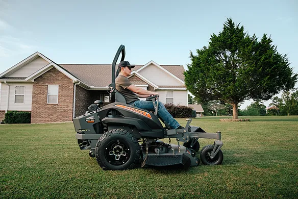 Operator running a Spartan Zero-Turn mower at a residential property.